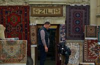 Traditional handcrafted carpets displayed at a shop entrance in Baku, Azerbaijan, showcasing vibrant cultural artistry.