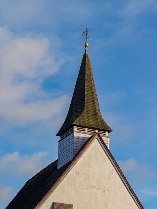 Free Close-up view of a charming church steeple rising against a vibrant blue sky. Stock Photo