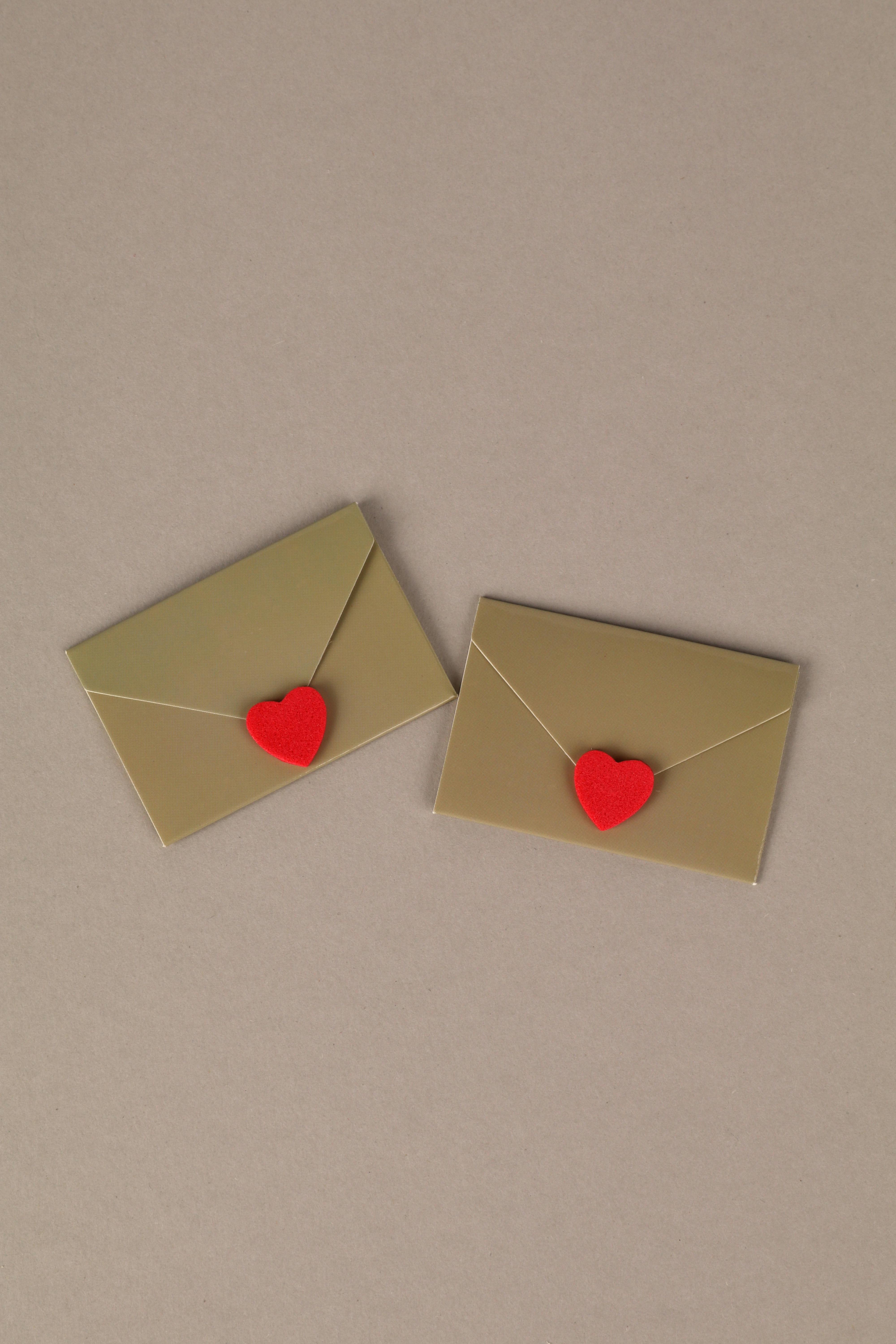 Two golden envelopes with red heart seals on a neutral background. Perfect for love themes.