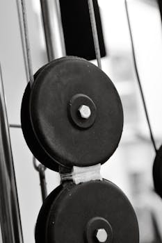 Detailed view of fitness machine pulley showcasing weight plates in black and white.