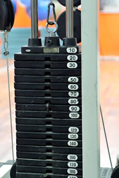 Detailed view of gym weight stack equipment with various weights visible on a machine.