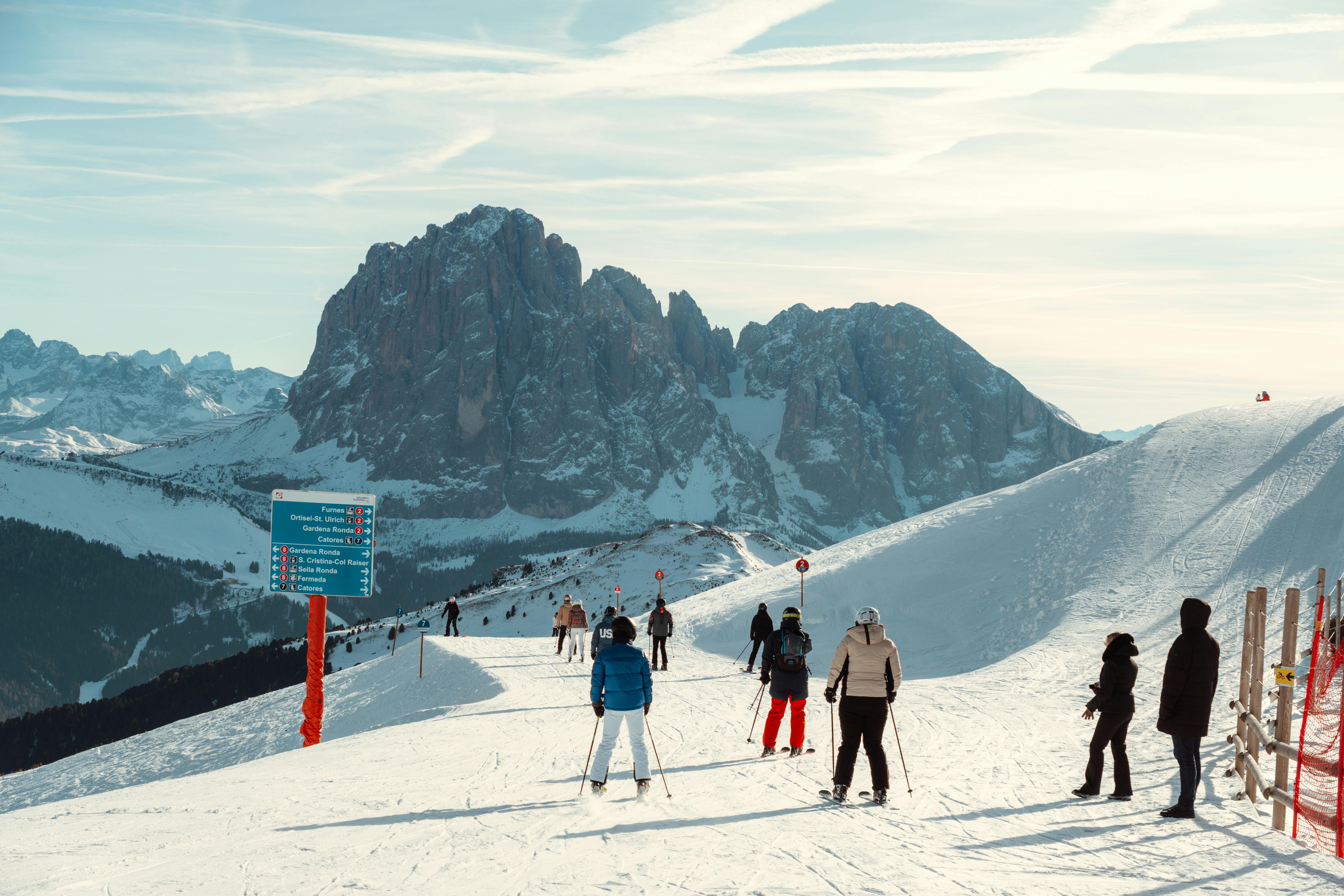Des skieurs profitent d'une journée ensoleillée dans les Dolomites, avec une vue imprenable sur les montagnes.