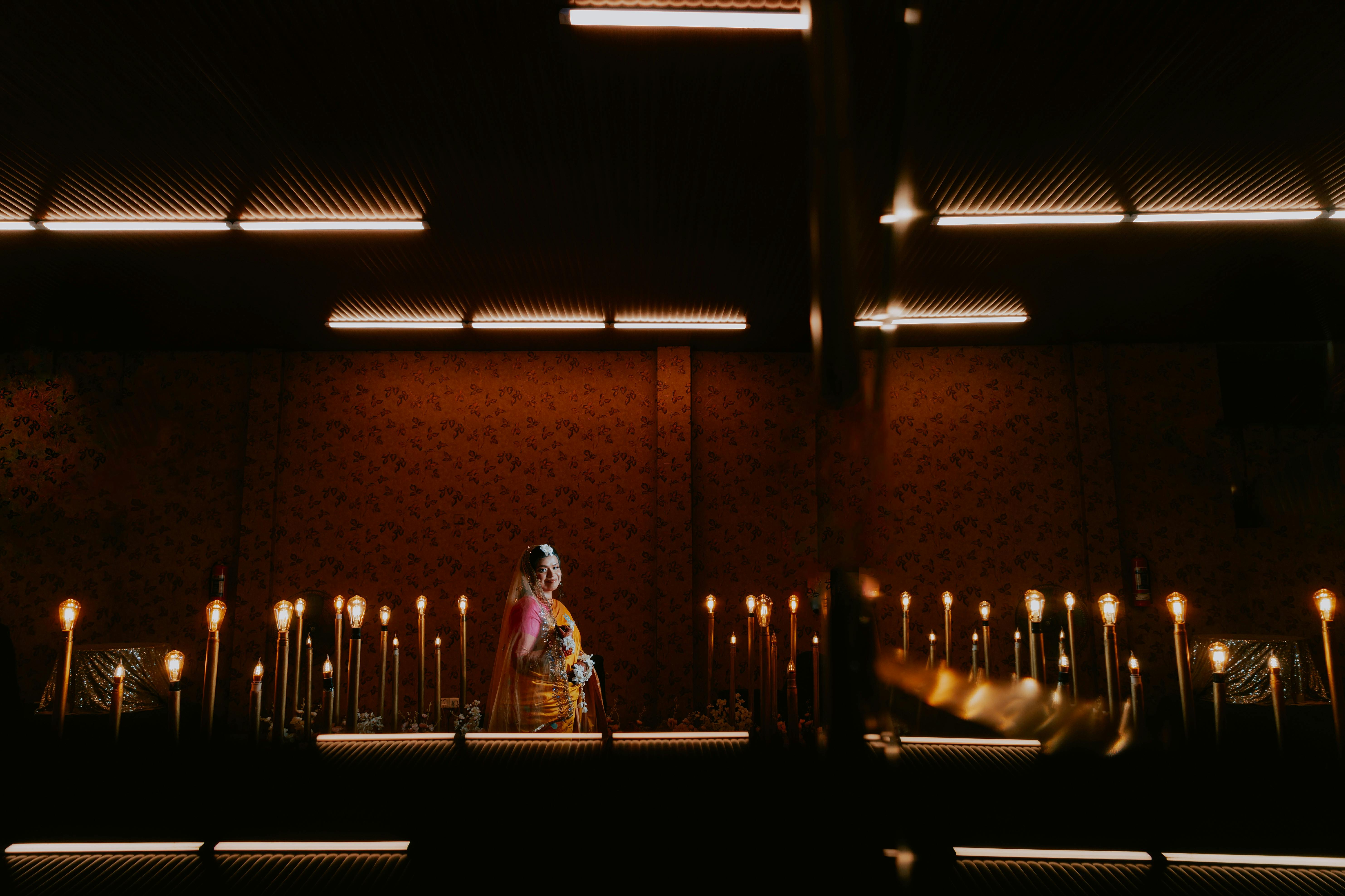 Kostenlos Braut in traditioneller Kleidung inmitten von Kerzenlicht, in einem Innenraum. Stock-Foto