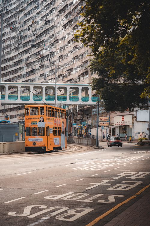 Free Vintage tram on Hong Kong street showcasing urban life and modern architecture. Stock Photo