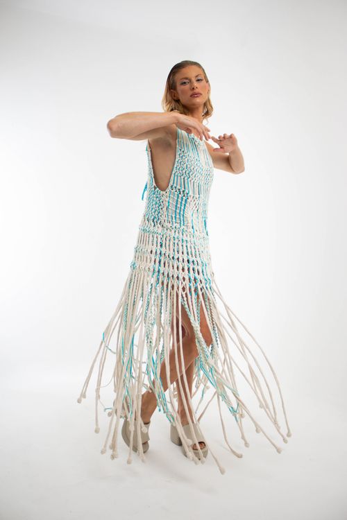 Free Fashionable woman posing in a unique, handcrafted fringe dress against a white backdrop. Stock Photo