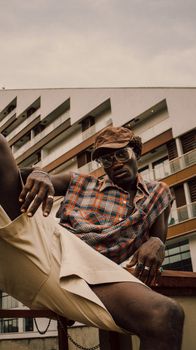 Stylish African man poses in contemporary clothing against urban backdrop in Ghana.