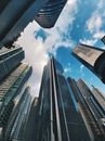 现代摩天大楼低角度映衬着蓝天白云，展现城市建筑风貌