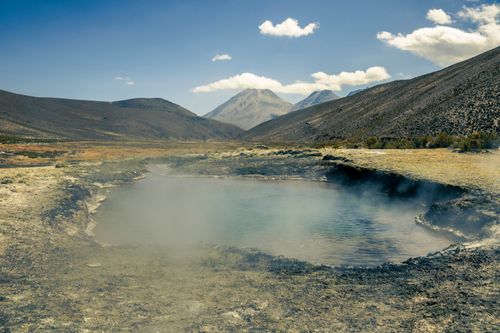 Free Geothermal pool amidst majestic mountains in Tacna, Peru under a clear blue sky. Stock Photo
