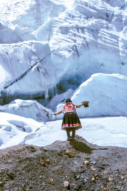 Woman in traditional Andean dress at a glacier in Cuzco, Peru, showcasing cultural heritage.