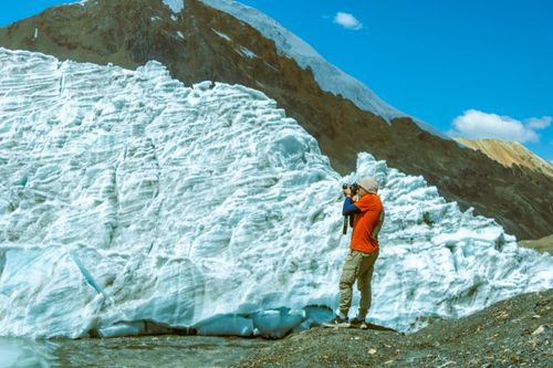 Free A photographer in Cuzco, Peru captures stunning glacier views with a scenic mountain backdrop. Stock Photo