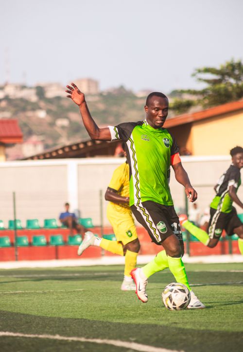 Free Dynamic shot of an African football player on a soccer field during a match. Stock Photo