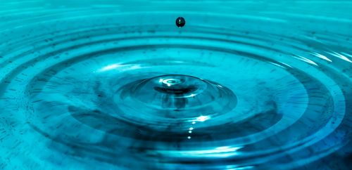 Free Captivating close-up of a water droplet creating ripples, illustrating motion and serenity. Stock Photo