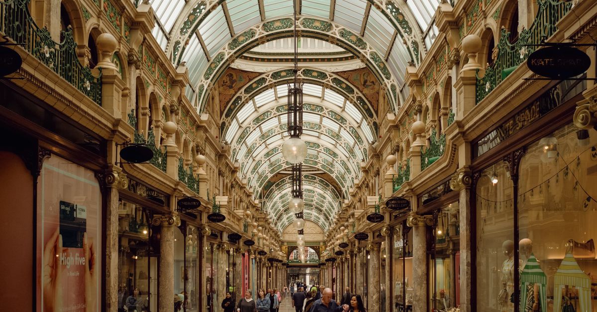 Stunning Victorian architecture with arched glass ceiling in a bustling Leeds arcade.