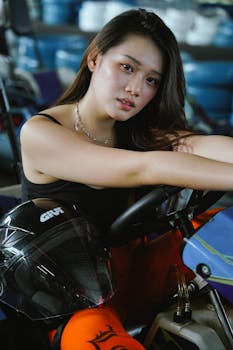 Confident young woman in a go-kart, ready to race, featuring modern helmet and racing gear.