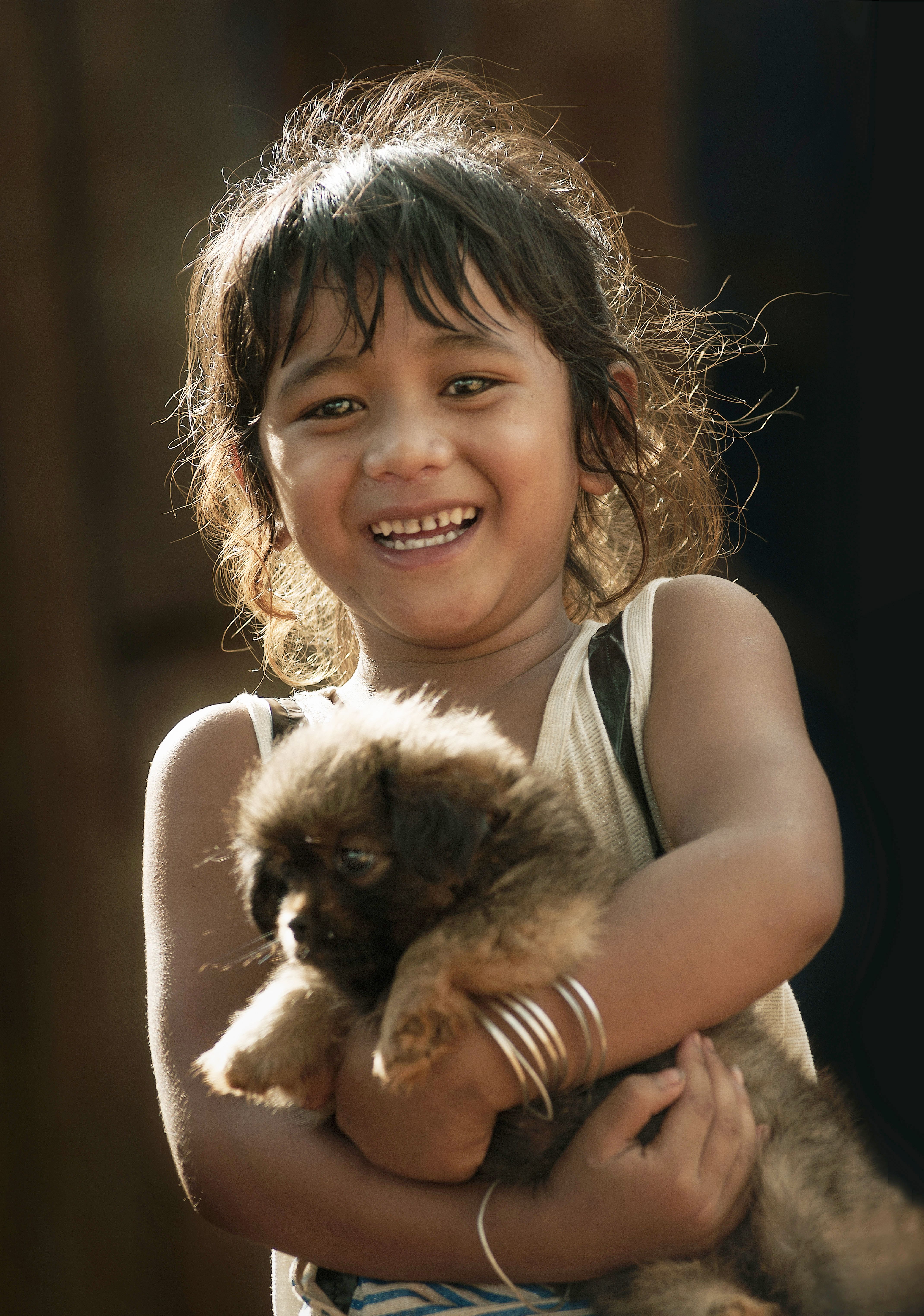 A happy child hugging a fluffy puppy, showcasing pure joy and innocence.