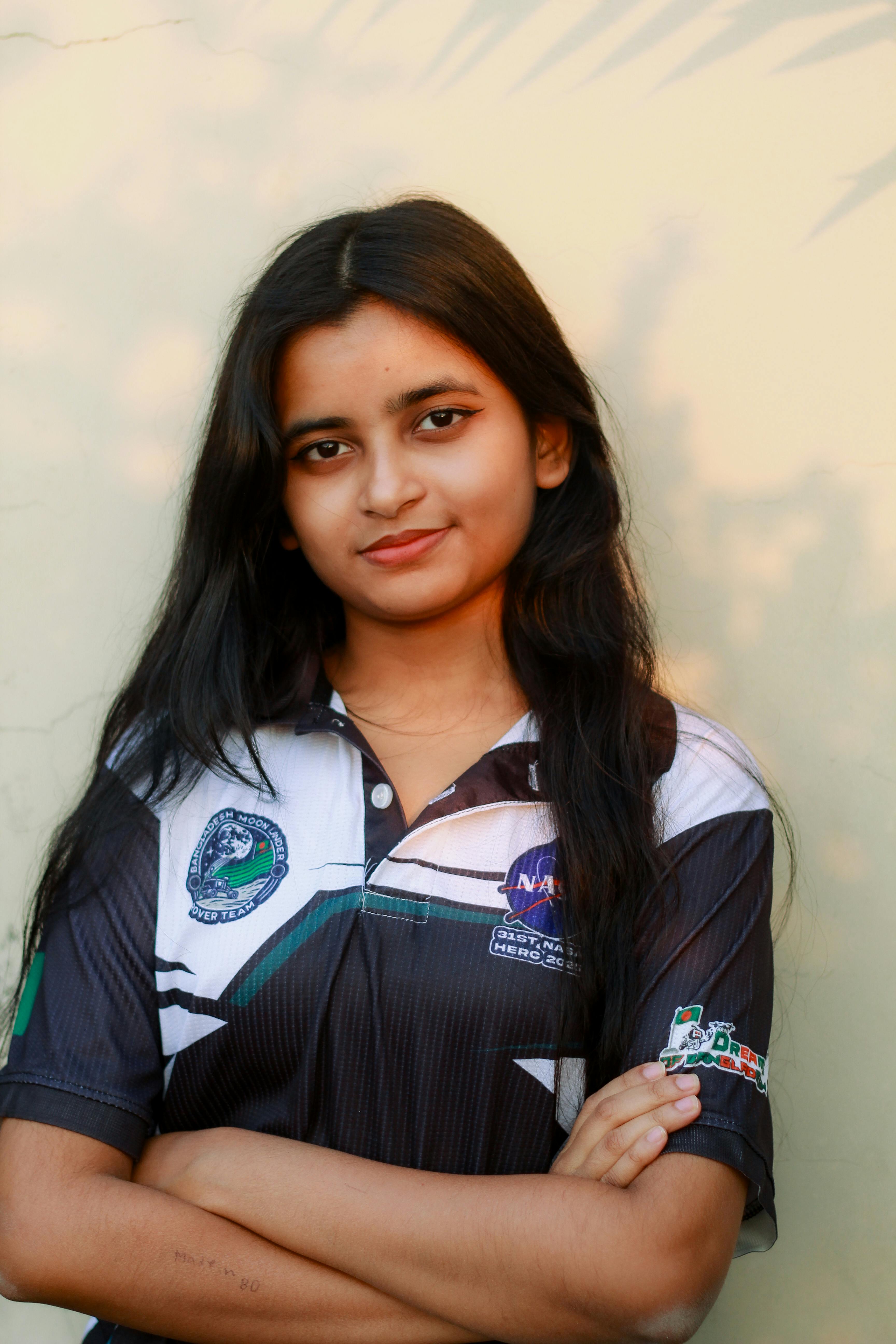 Gratis Una joven segura de sí misma posando al aire libre en Dhaka, Bangladesh, vistiendo una camiseta con la temática de la NASA. Foto de stock
