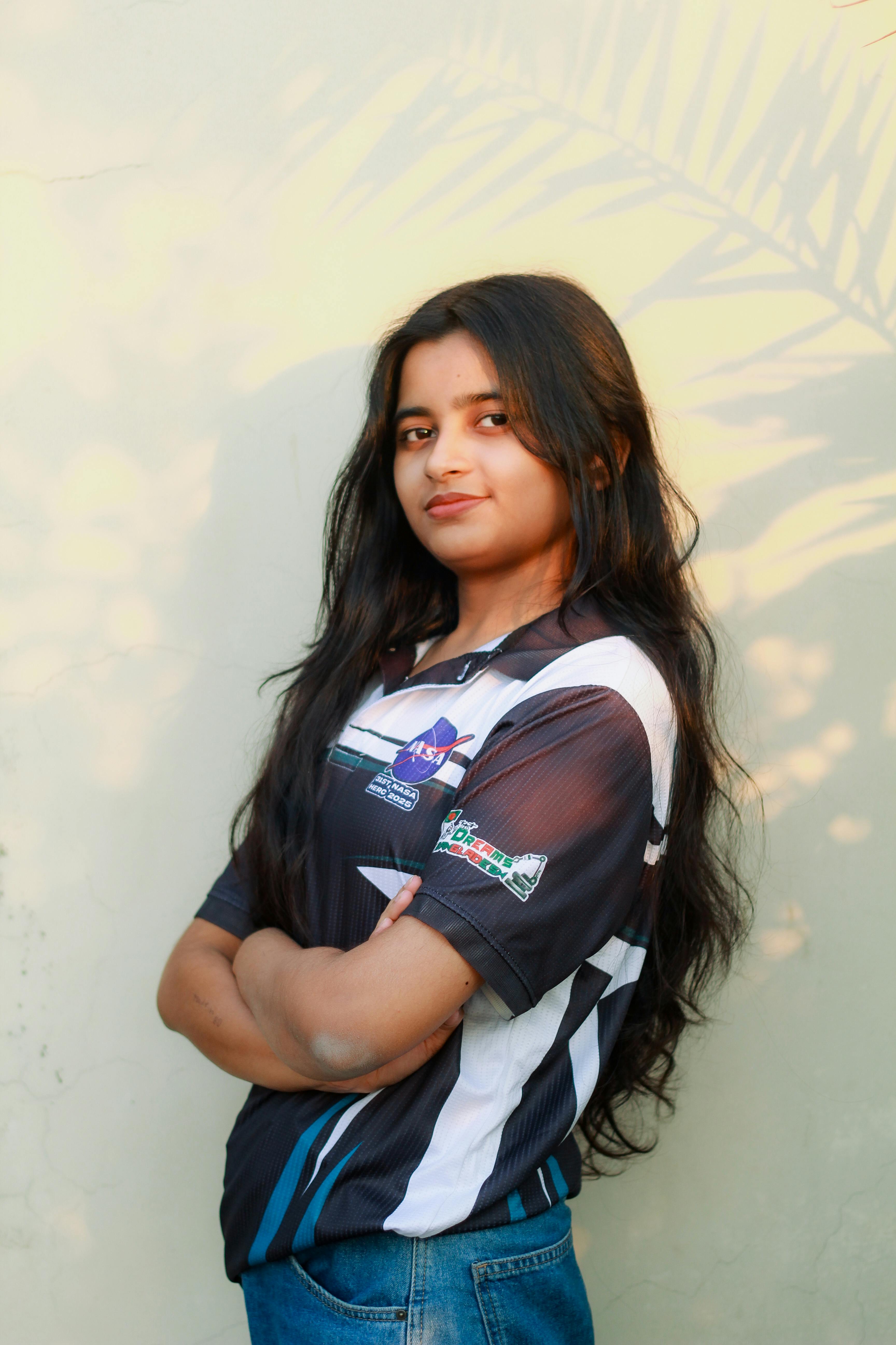 Gratis Retrato de una mujer joven con una camiseta del equipo de robótica, de pie con confianza al aire libre en Dhaka, Bangladesh. Foto de stock