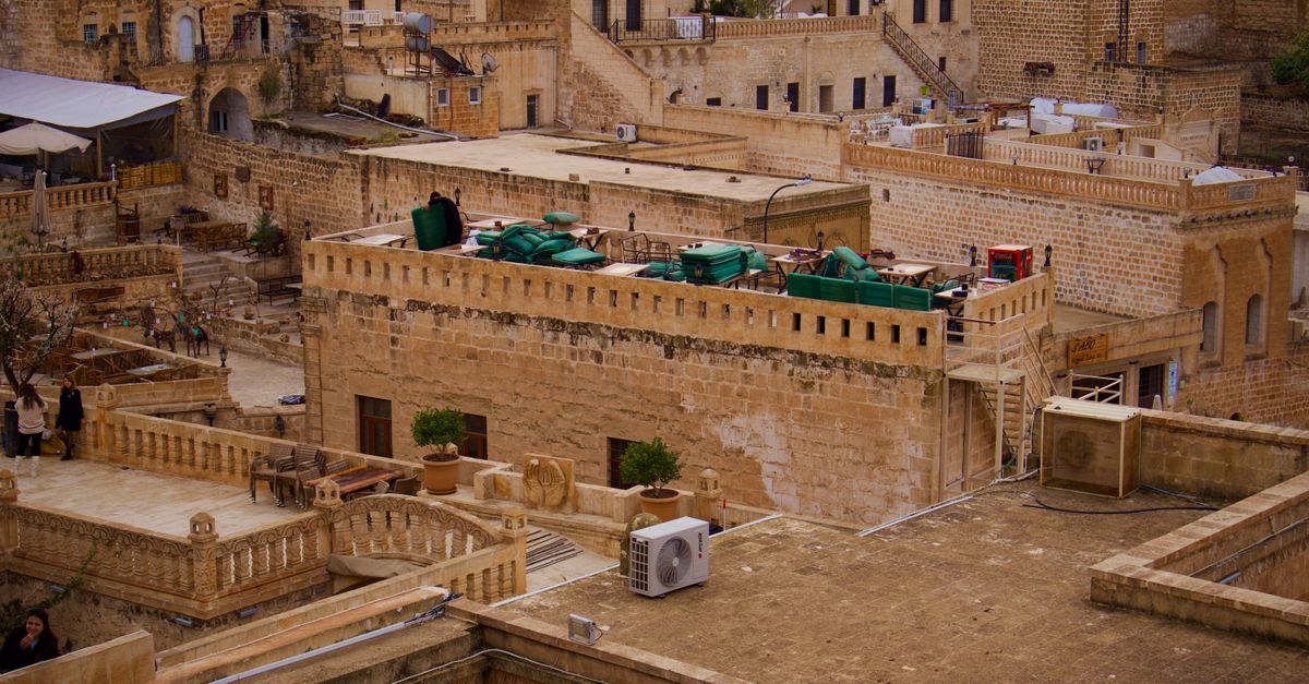 Rooftop terrace at a Jordanian hostel with students studying and sunset view