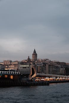 Scenic view of Galata Tower and Galata Bridge in Istanbul during evening twilight.