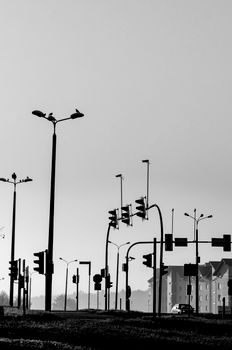 Monochrome view of streetlights and traffic signals on a city street in Tychy, Poland.