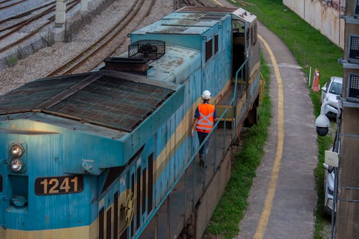 Un operaio ferroviario ispeziona una locomotiva blu sui binari a Belo Horizonte, in Brasile.