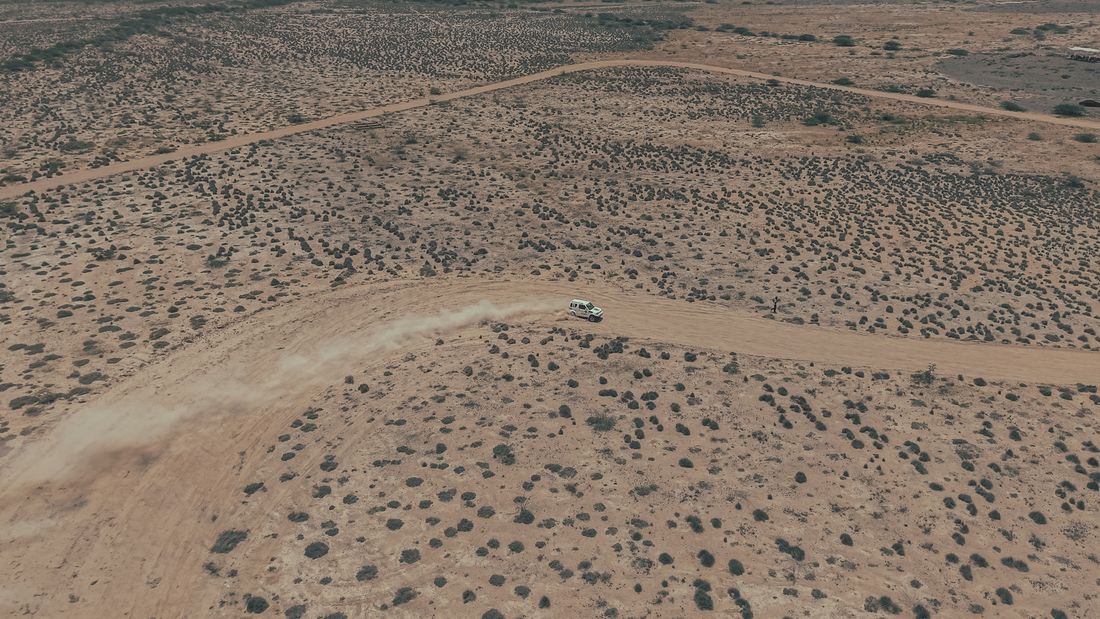 Aerial view of an off-road vehicle crossing a desert landscape
