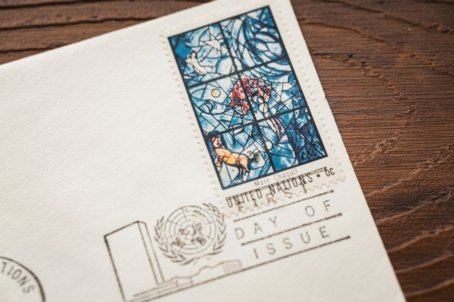 Close-up of a vintage postage stamp featuring artwork by Marc Chagall on a wooden table.