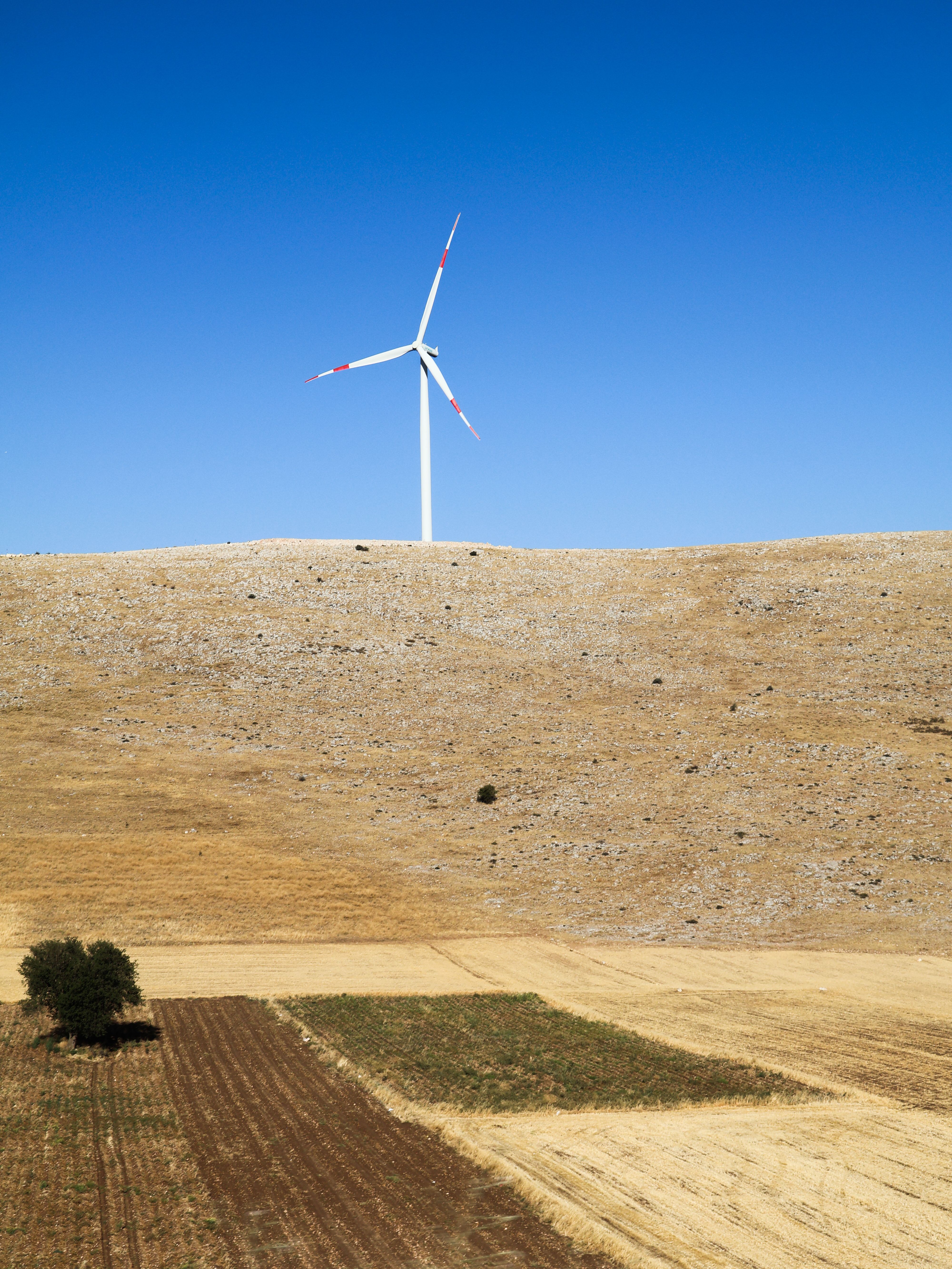 Wind Turbine on Arid Landscape under Clear Blue Sky · Free Stock Photo