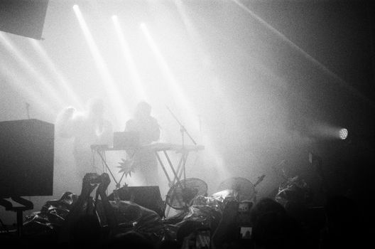 Energetic concert photo with musicians in foggy lighting.
