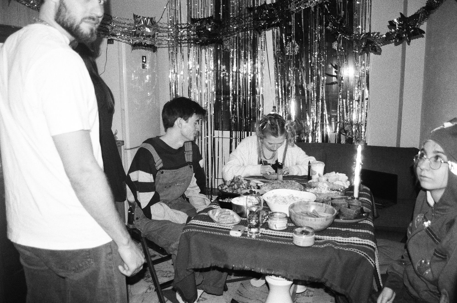 Friends sharing a relaxed dinner around a table in black and white