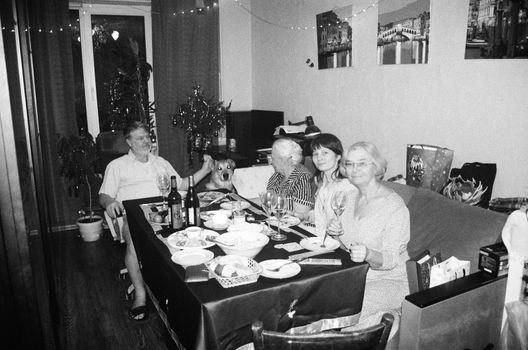 Monochrome image of a family dinner gathering in a cozy home setting.