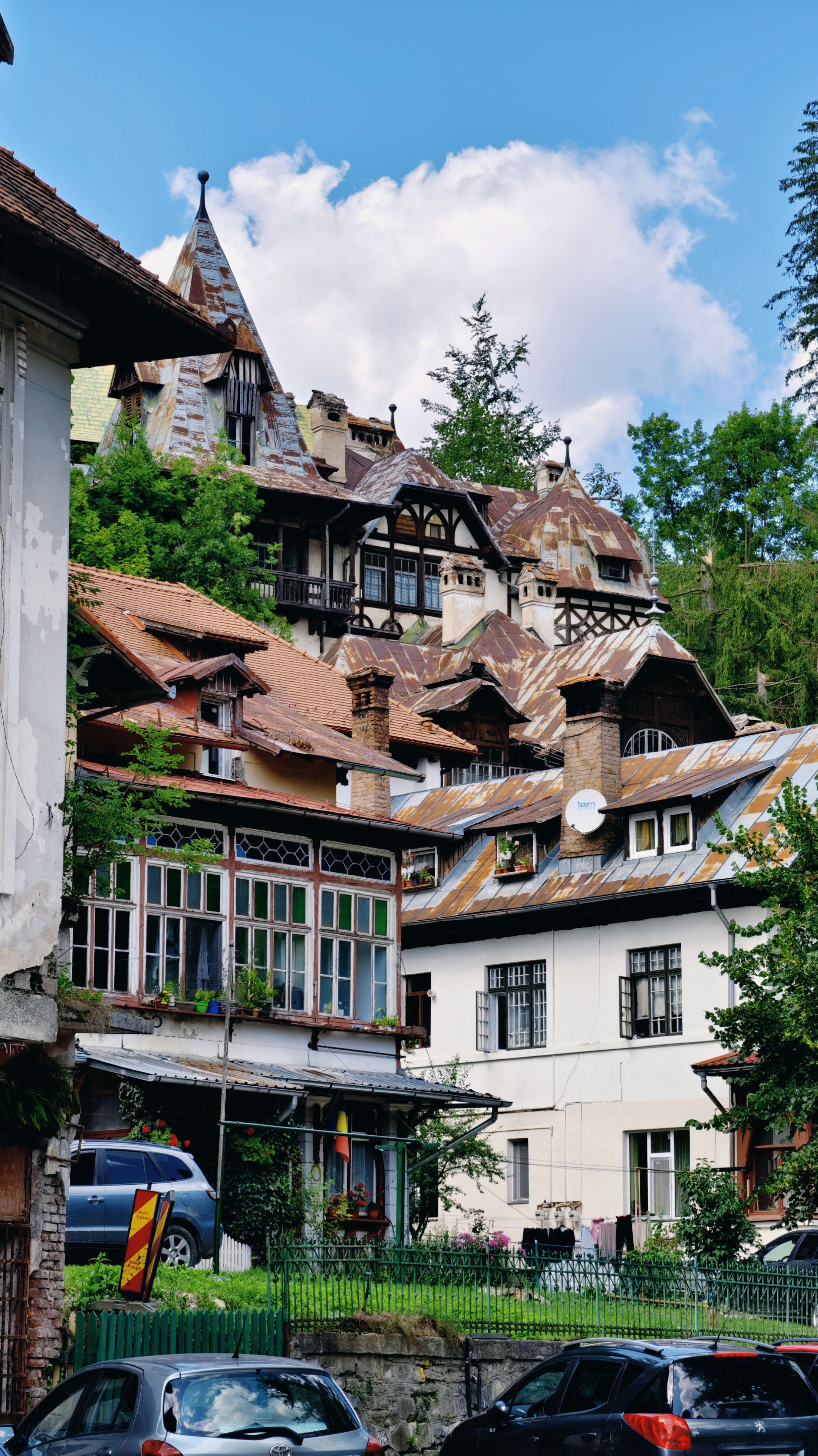 Charming village scene with rustic European architecture amid lush greenery under a clear sky.