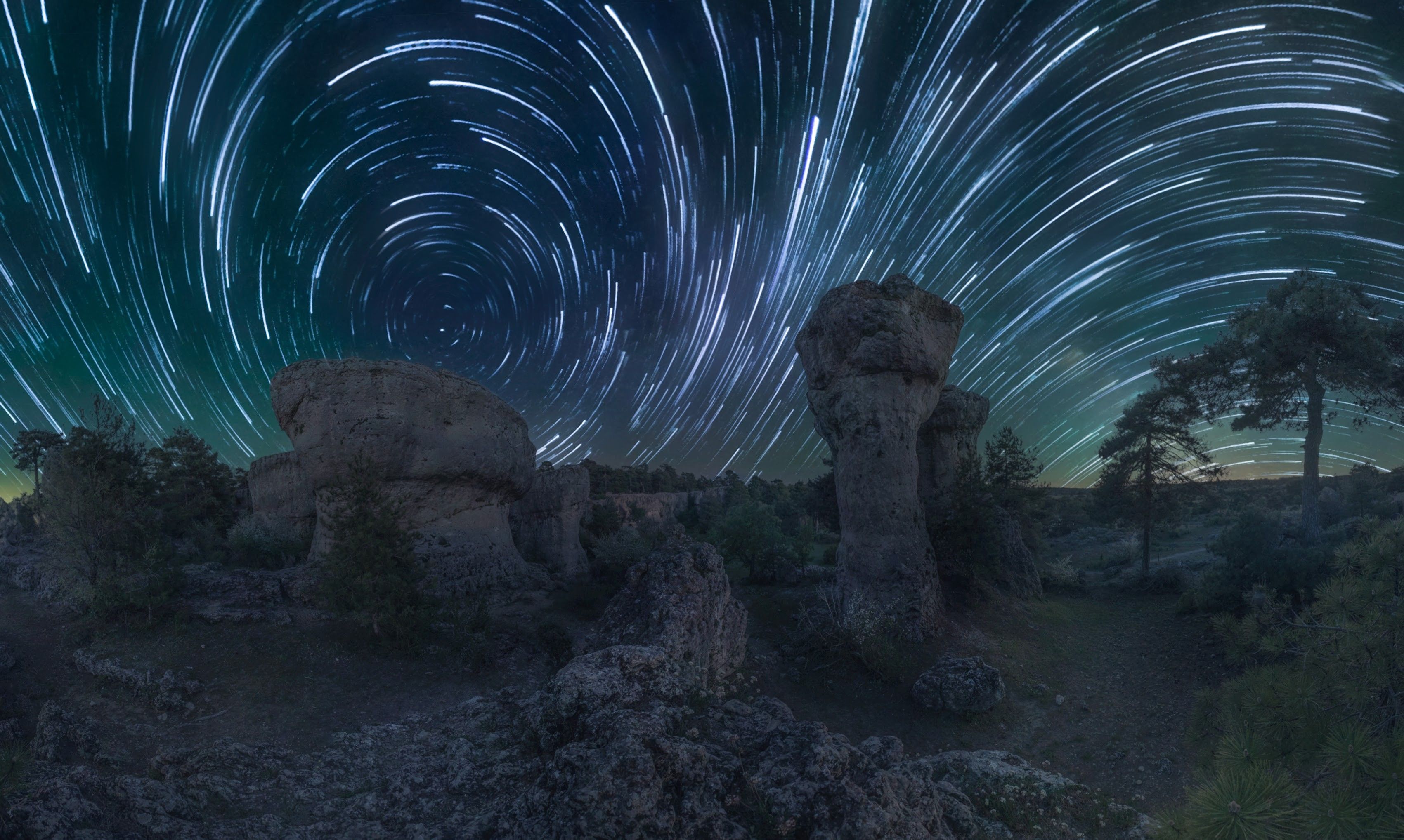 Stunning Night Sky with Star Trails over Rock Formations · Free Stock Photo
