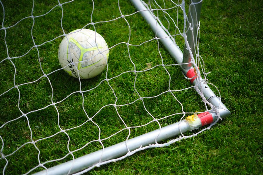 Close-up of a soccer ball resting in a goal net