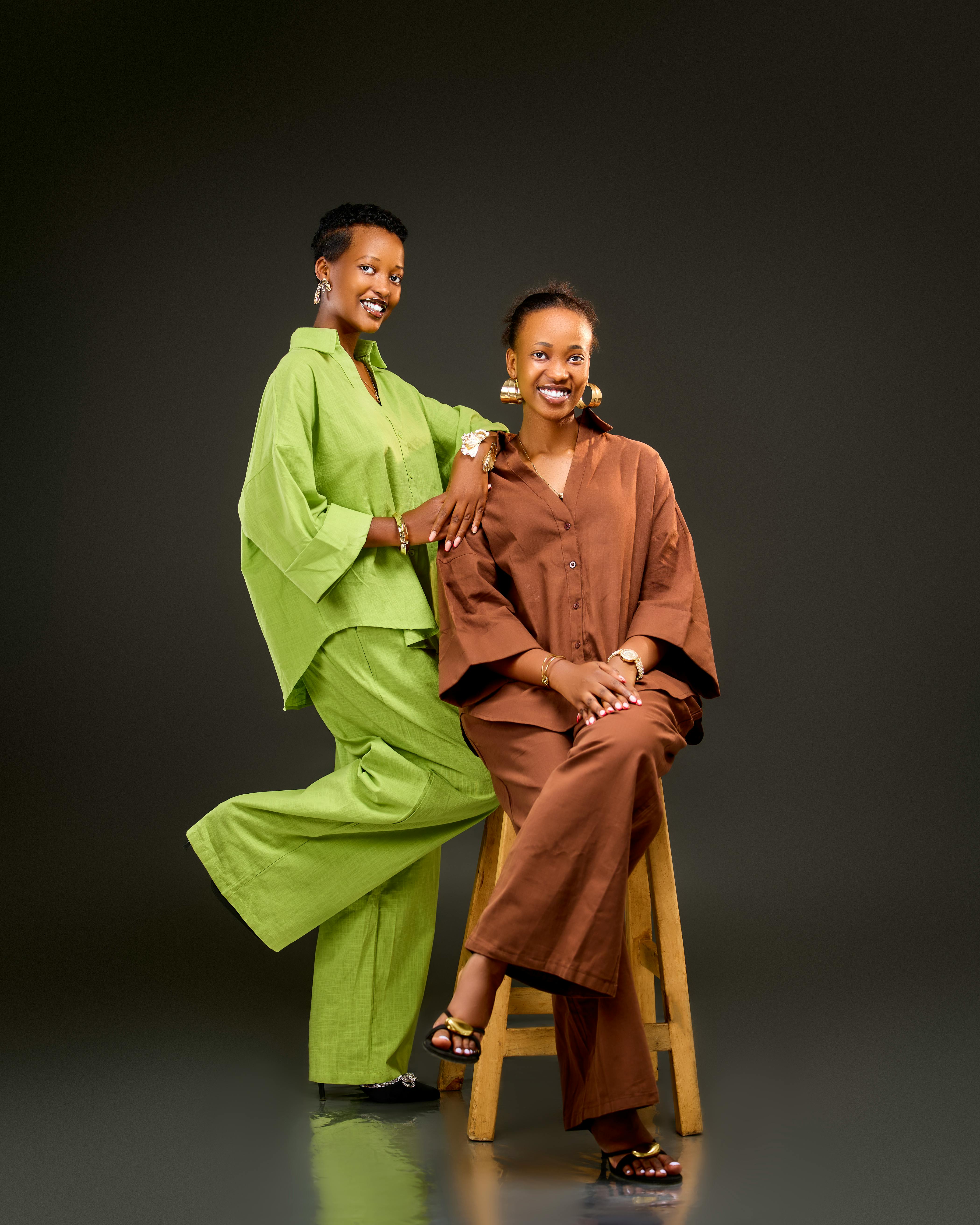 Zadarmo Dve ženy pózujú v rovnakých módnych outfitoch a predvádzajú moderný štýl v štúdiovom prostredí. Fotka z fotobanky