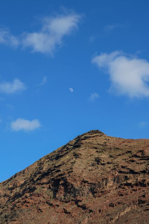 Free Stunning view of rugged mountain under blue sky with moon visible, Gran Canaria. Stock Photo
