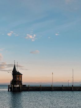 Scenic view of Konstanz harbor tower against a pastel sky during sunset.