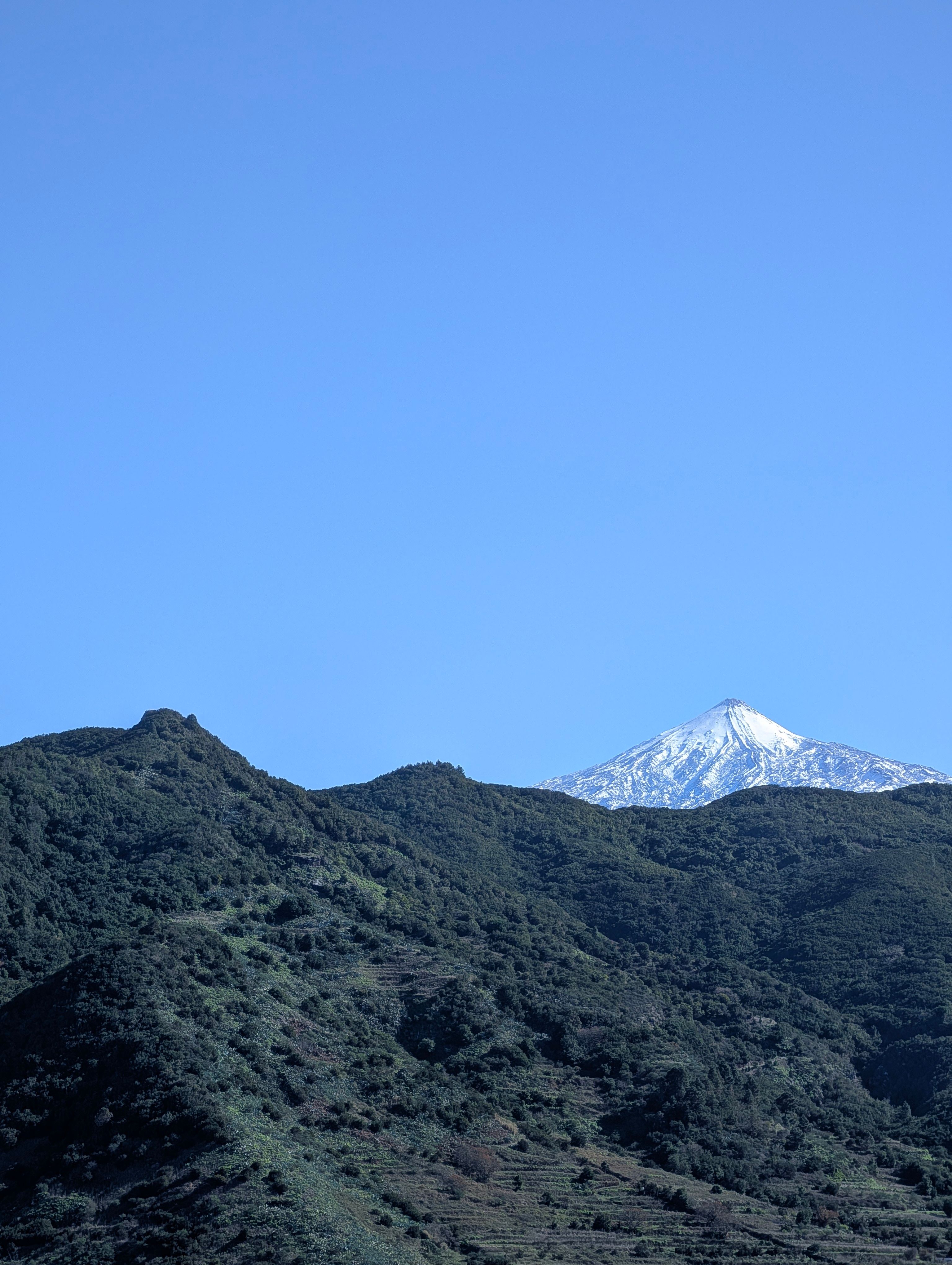 A stunning snow-capped mountain peak under a clear blue sky, showcasing natural beauty.