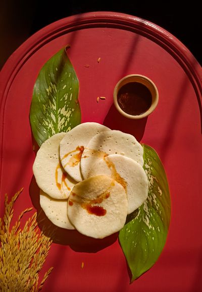 Fluffy Indian pancakes served on a leaf with chutney