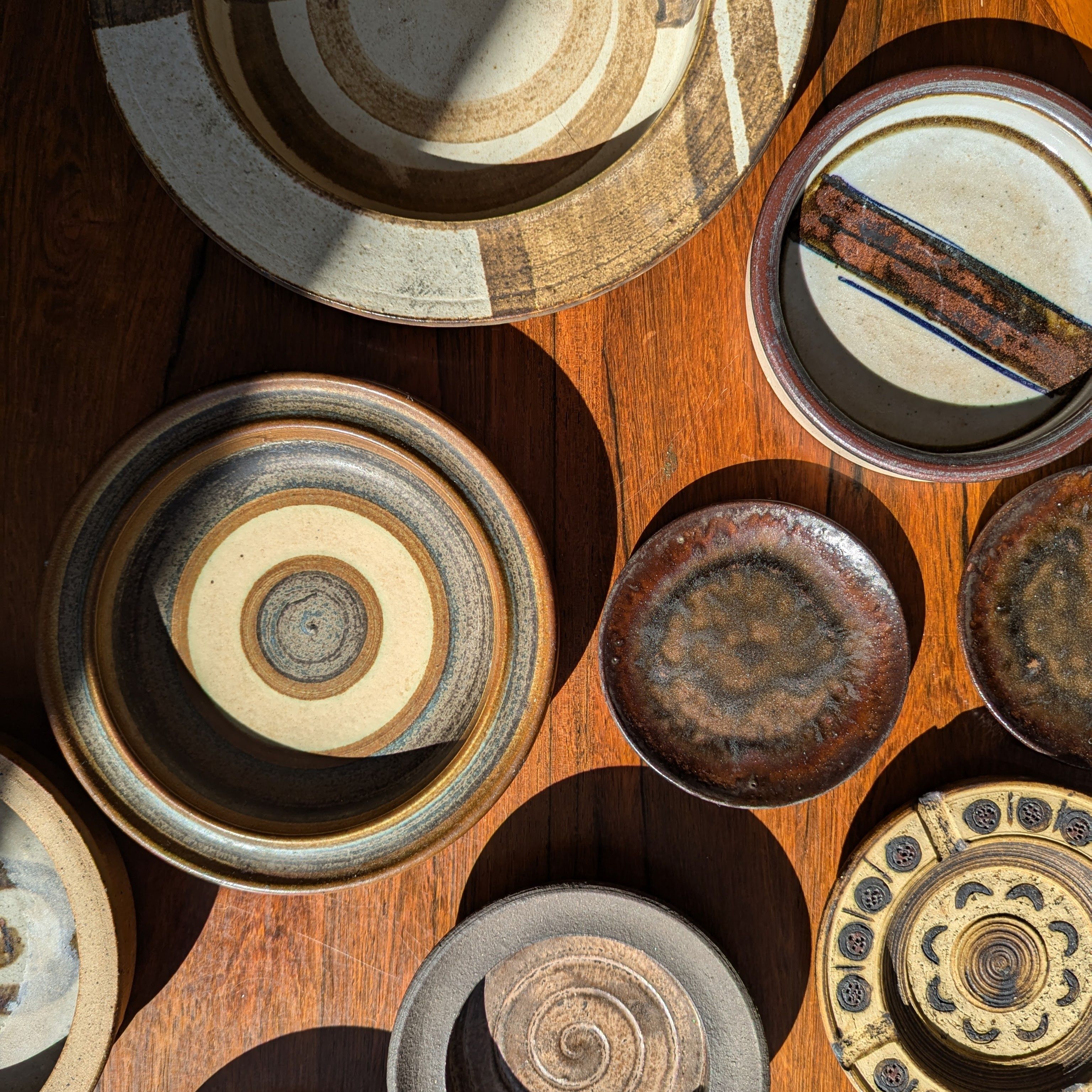 Handcrafted pottery pieces drying in sunlight