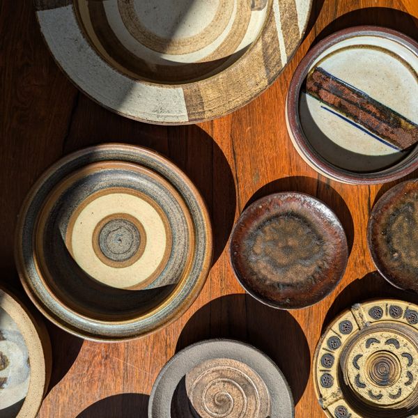 Row of glazed ceramic bowls on a wooden bench, photo by nic godsell on Pexels