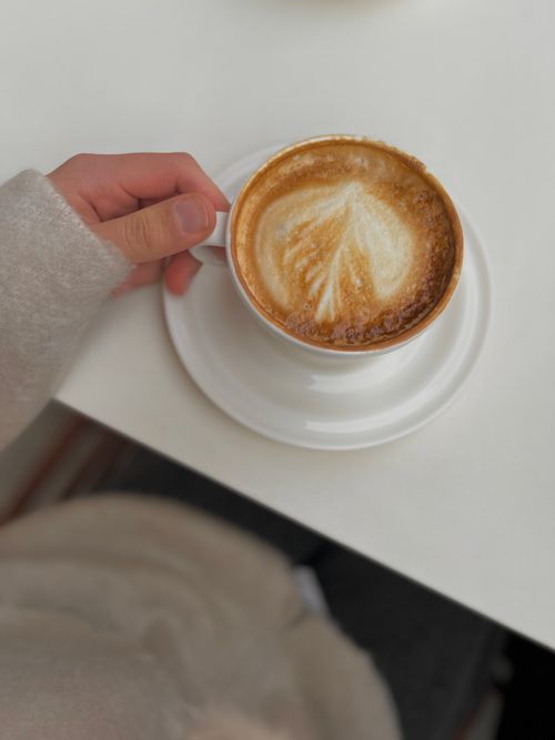 Free Warm cappuccino with latte art in a cozy setting, top view. Stock Photo