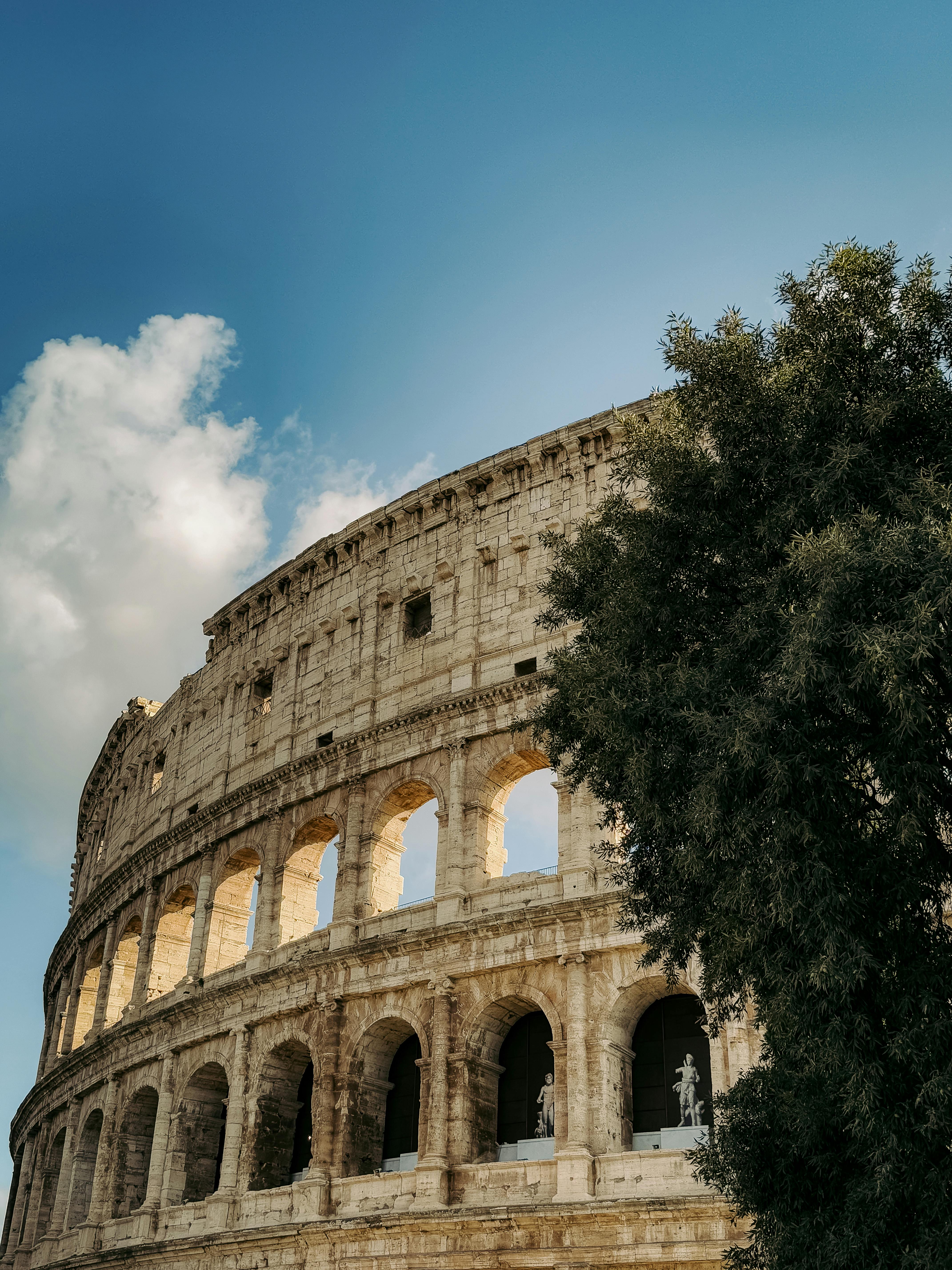Free Capture of the iconic Colosseum with blue sky in Rome, Italy. Stock Photo