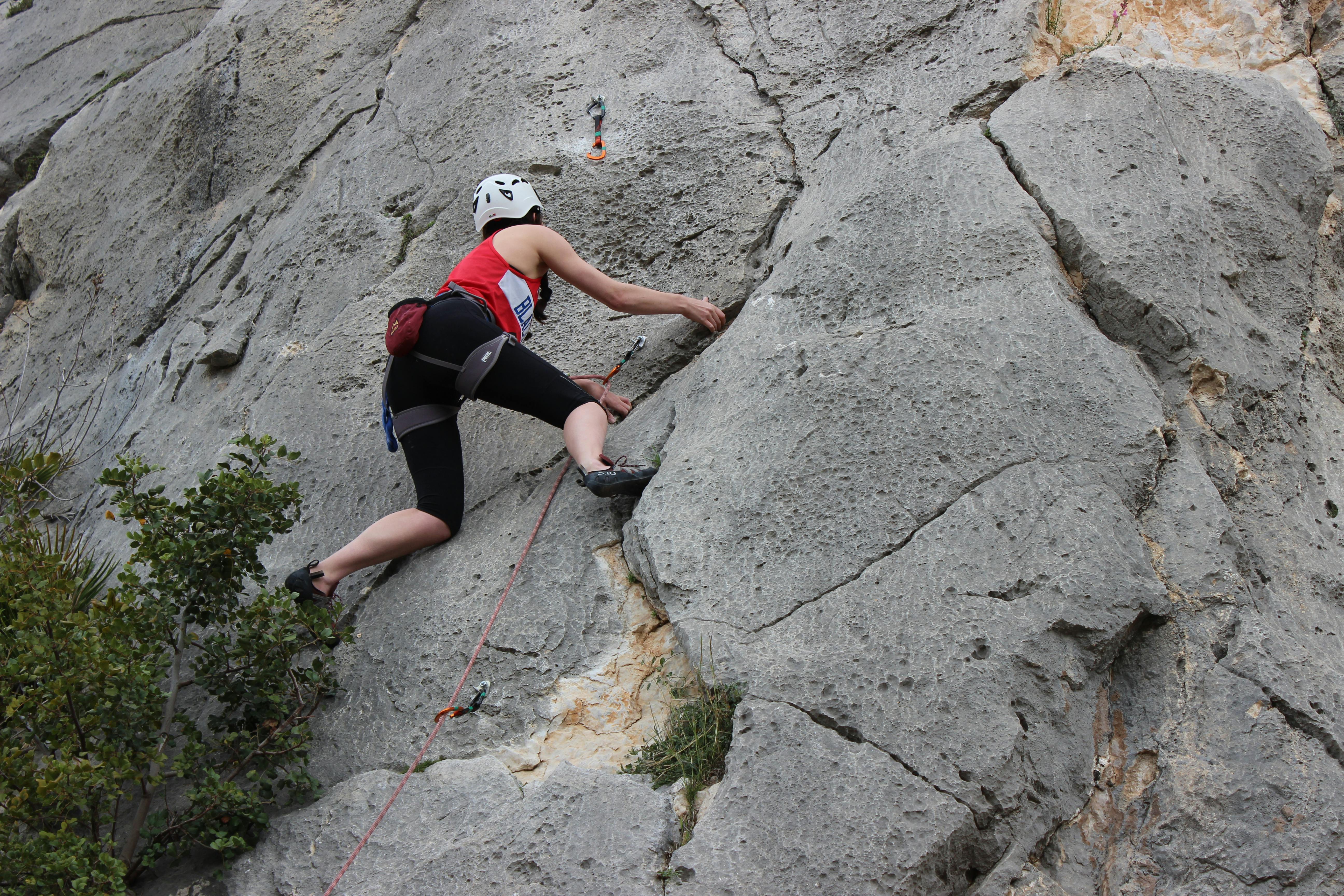 A climber ascends a rugged cliff face in El Chorro, Andalusia, Spain, capturing adventure and skill.
