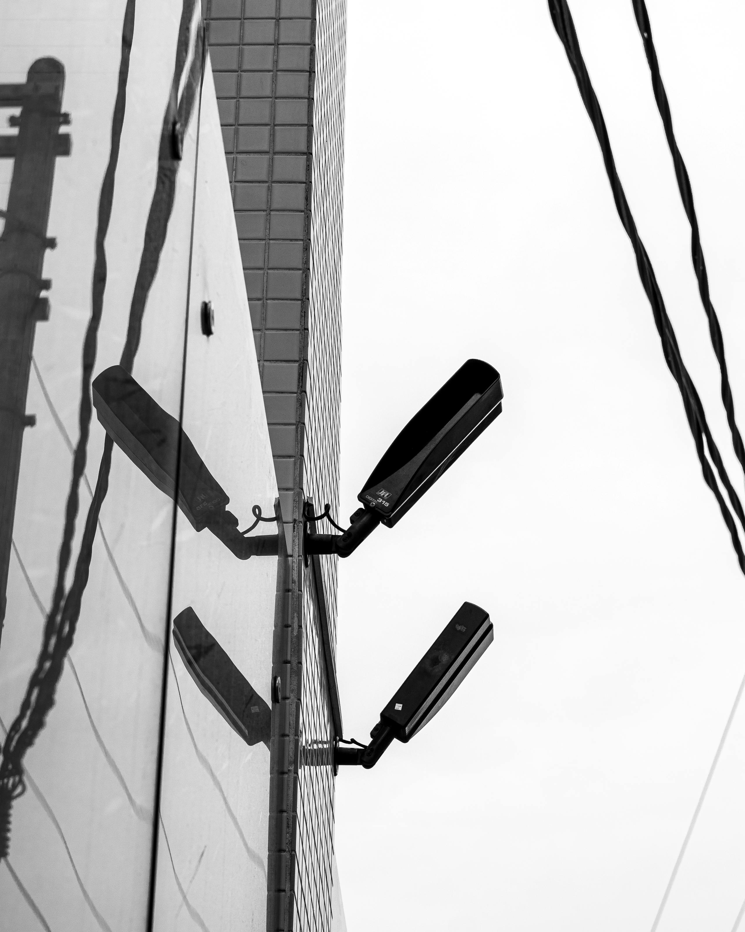 Gratis Fotografía en blanco y negro de arquitectura urbana con reflejos y farolas. Foto de stock