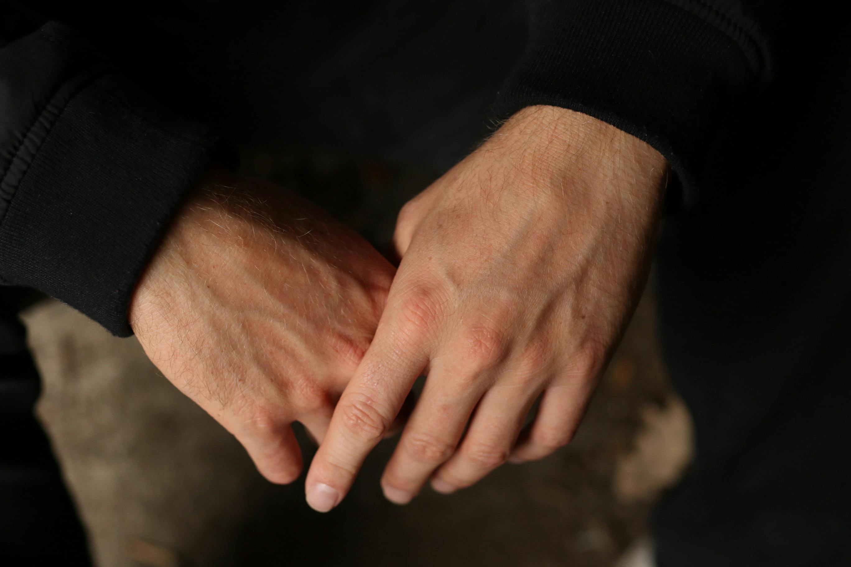 gratis Een close-up van de handen van een man, met een stemmige, donkere tint en natuurlijk licht. Stockfoto