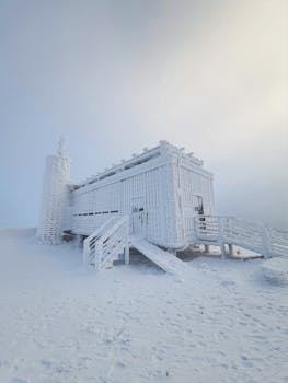 A stunning snow-covered cabin in winter in Karpacz, Poland under a bright sky.