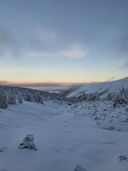 Beautiful snowy landscape in Karpacz, Poland, captured at sunset with a serene winter vibe.