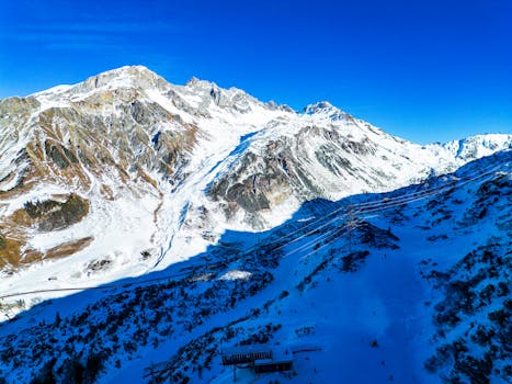 A breathtaking aerial view of the Austrian Alps covered in snow, showcasing a winter wonderland.