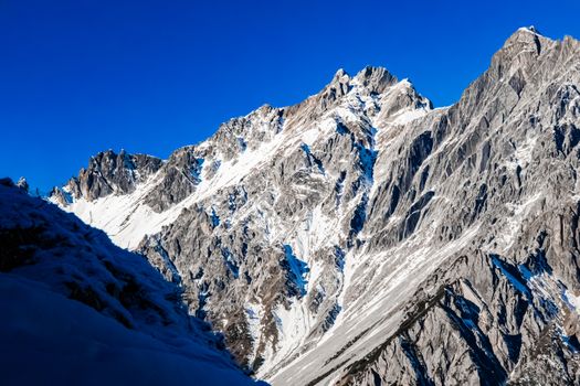 Stunning view of snow-covered mountain peaks in the Austrian Alps under clear blue skies.